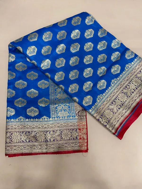 Humairah_Presents_Blue_Satin_Silk_Silver_Zari_Floral_Boota_and_Contrast_Red_Zari_Border_and_Heavy_Silver_Zari_Floral_Anchal_Banarasi_Saree_with_Red_Blouse